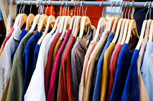 Sale of clothing in the store Lots of colorful Tshirts on the hanger © Igor Luschay