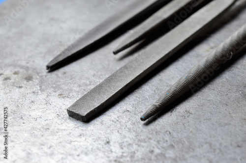 several metal files are on the metal surface. close-up.
