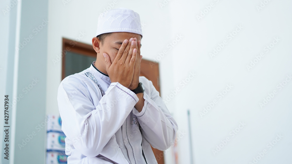 A portrait of an asian muslim man pray at mosque, the pray name is sholat, regards end of sholat A portrait of an asian muslim man pray at mosque, the pray name is sholat, regards end of sholat
