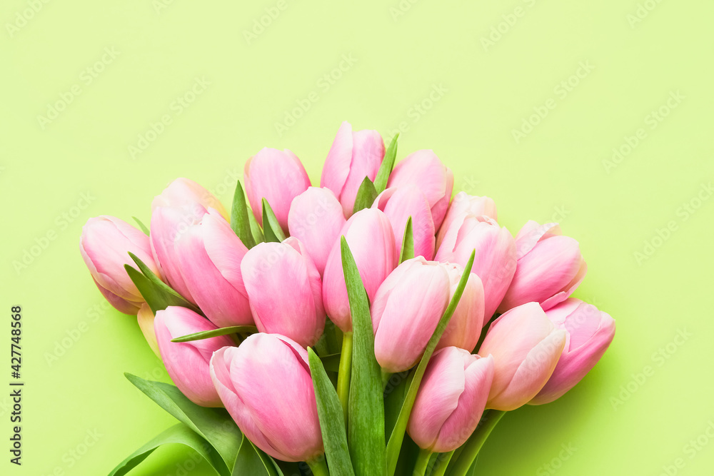 Pink tulips bouquet on a green background, selective focus. Mothers Day, birthday celebration concept. Pink tulips bouquet on a green background, selective focus. Mothers Day, birthday celebration concept.