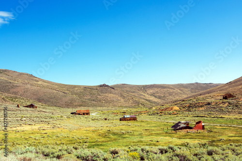 Scenic view of desert landscape and abandoned wooden houses at Bodie ghost town.