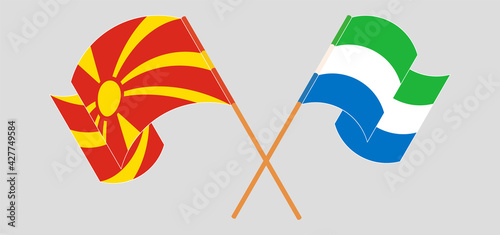 Crossed and waving flags of North Macedonia and Sierra Leone