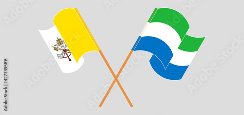 Crossed and waving flags of Vatican and Sierra Leone