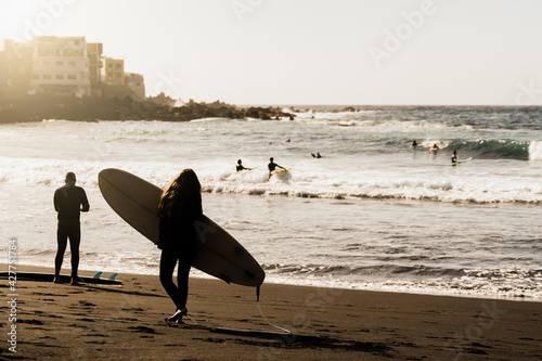 Photography Young surfer friends surfing on the beach at summer sunset - Silhouette of peopl