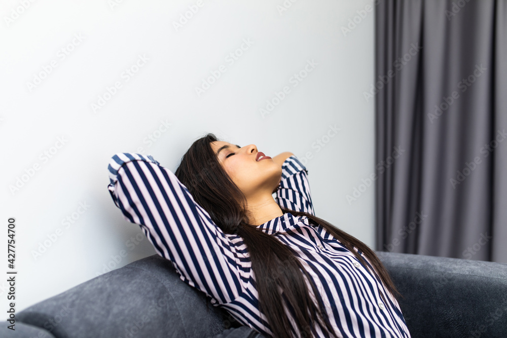 Obraz premium Closeup of a smiling young woman lying on couch