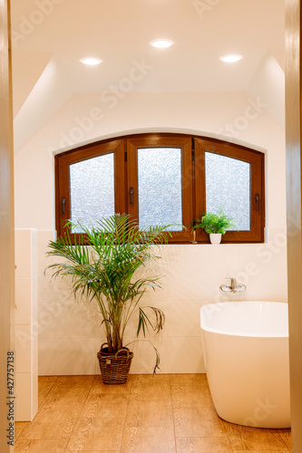 Beautiful  bright bathroom in country house style  with tiles in wood look. Large bathroom in a country house  with wood and white tiles. Freestanding bath 