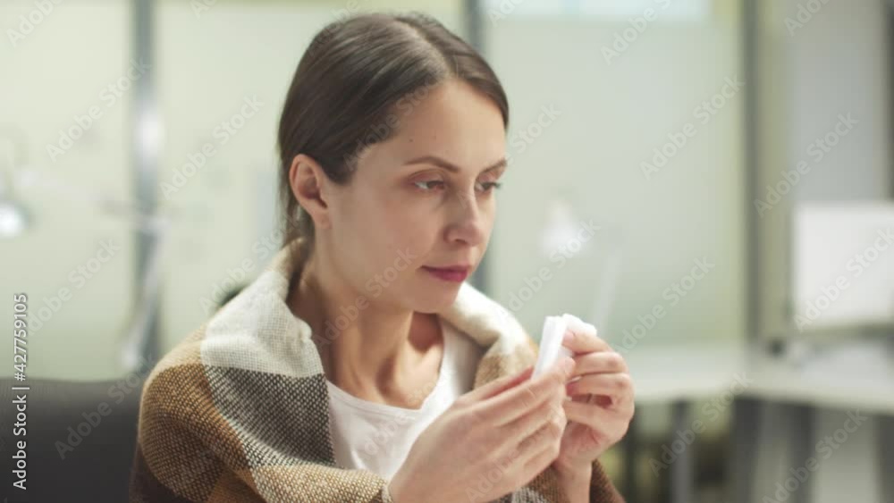 The young woman fell ill, she has chills, she wrapped herself in a blanket, sore throat, cough, runny nose The young woman fell ill, she has chills, she wrapped herself in a blanket, sore throat, cough, runny nose