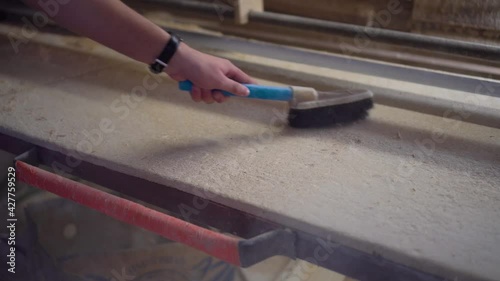 Cleans a workbench with a brush. Cleaning the workplace after work concept.