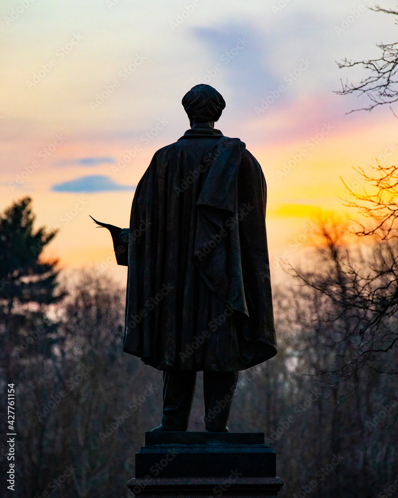 Naklejka premium Statue silhouette with sunset portrait background