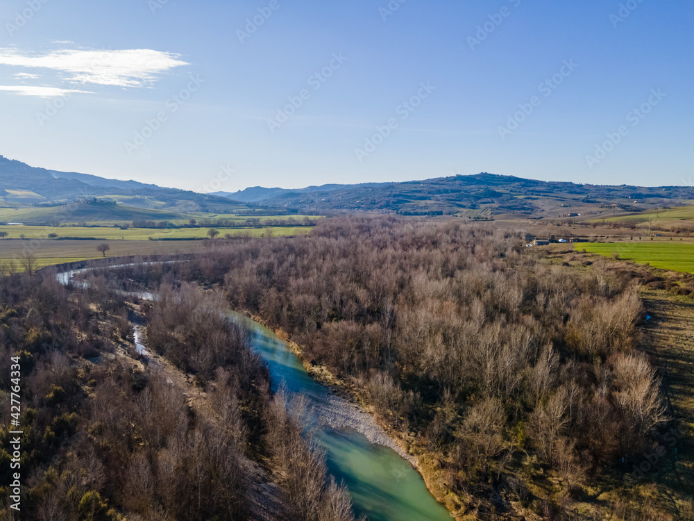 Landscape in autumn with a river and a forest. Drone shot, aerial view.