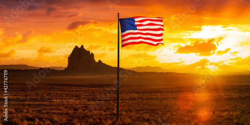 American National Flag Composite in dry desert with a mountain peak in the background. Colorful Sunset Sky Art Render. Taken at Shiprock, New Mexico, United States. photo