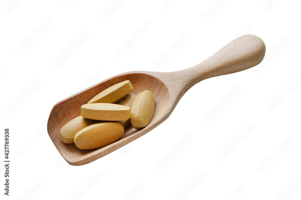 Vitamin pills in wooden measuring spoon on white background. Vitamin pills in wooden measuring spoon on white background.