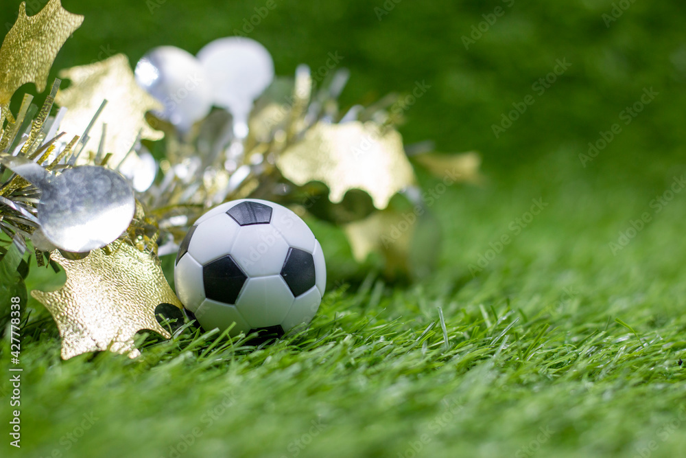 Fototapeta premium Soccer ball with Christmas Decoration on green grass for Christmas Holiday 