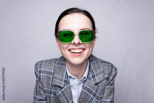female boss in a cage suit and green glasses