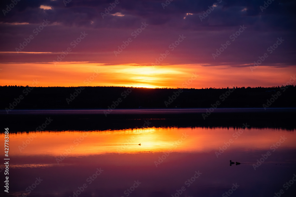 Sunrise with low clouds reflecting in water