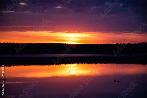 Sunrise with low clouds reflecting in water
