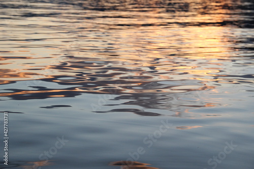 Golden yellow sunset reflection on the water surface of the lake