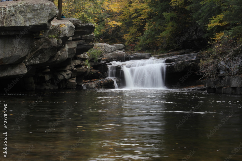 Fototapeta premium Colorful Vermont autumn foliage waterfall down the river in the forest