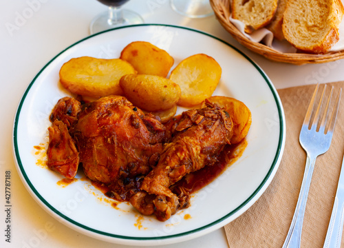 Tasty baked chicken and potatoes at plate