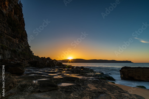 Sunrise seascape with headland and sunburst © Merrillie