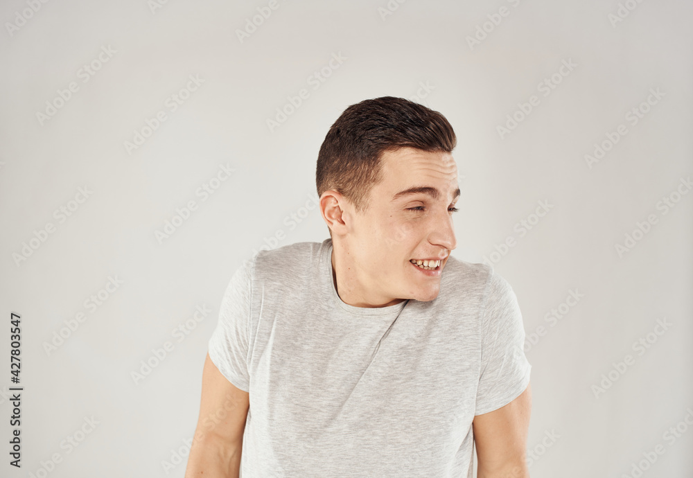 Man in white t-shirt emotions studio cropped view light background Man in white t-shirt emotions studio cropped view light background