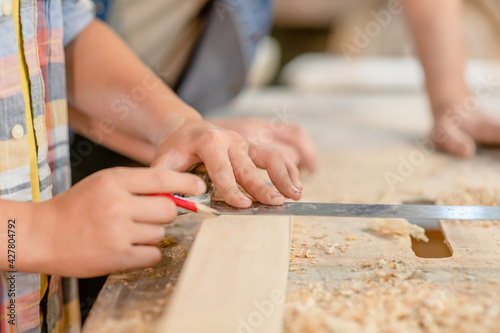 Father teaches son carpentry at a workshop