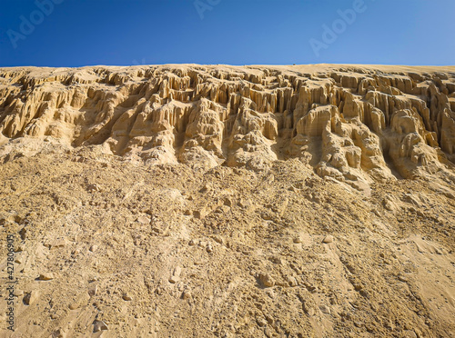 Formations of sand on the beach in Boa Vista Island, Cape Verde. Erosion of sandstone on the coast of Atlantic Ocean. Selective focus on the texture, blurred background.