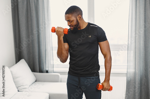 Handsome Afro American sportsman working out at home