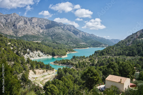 An idyllic lake between mountains. A famous city Guadalest reservoir in Alicante, Spain. © ruthlaguna