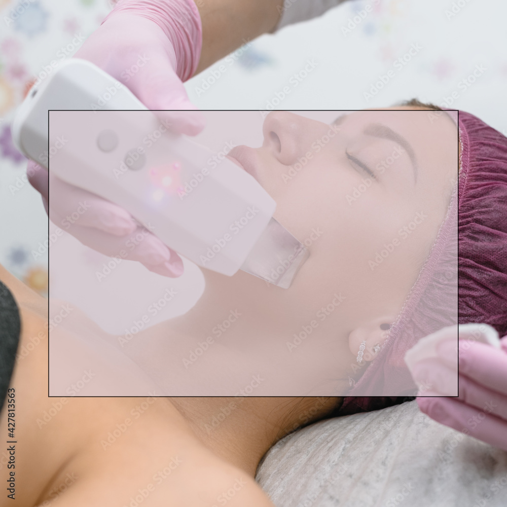 Naklejka premium Cosmetologist doing ultrasound rejuvenation procedure to female client in modern beauty salon, with field for ad text