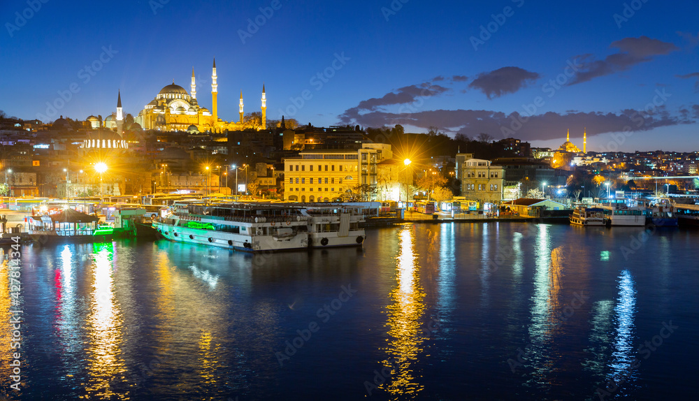 Scenic night view of Fatih district on bank of Golden Horn bay with marina and lighted Suleymaniye Mosque, Istanbul, Turkey
