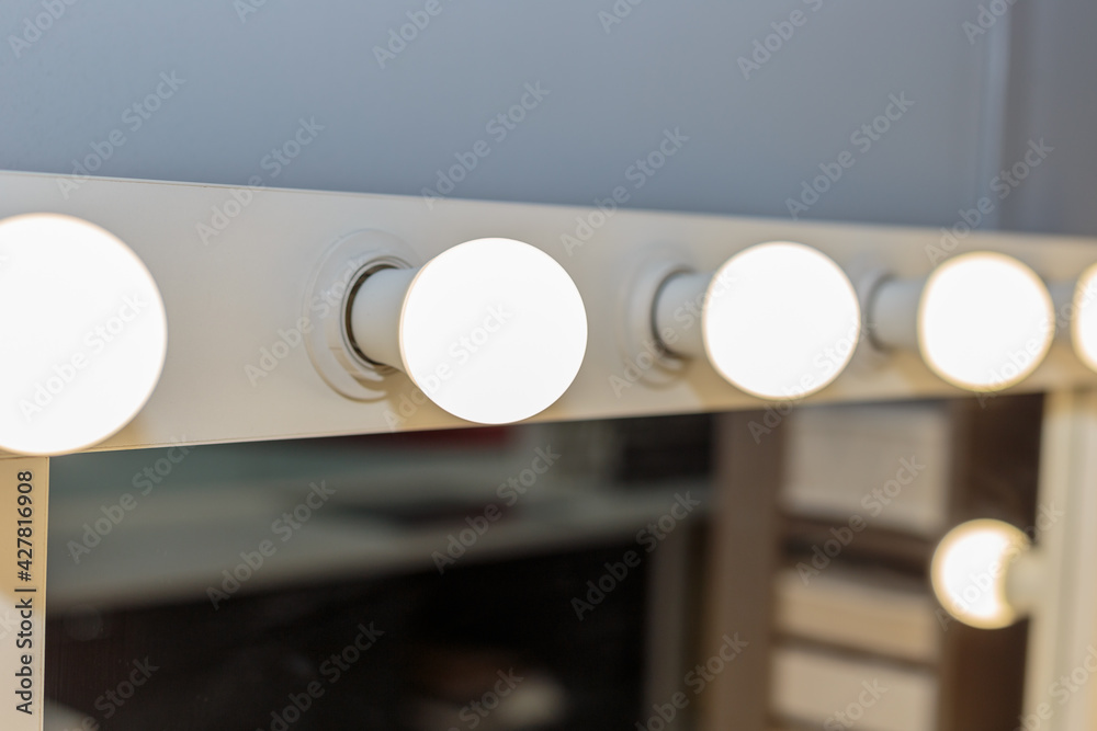 Beautiful white makeup table with light bulbs.