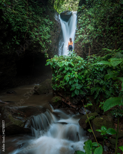 Woman enjoying beautiful waterfall in the mountain