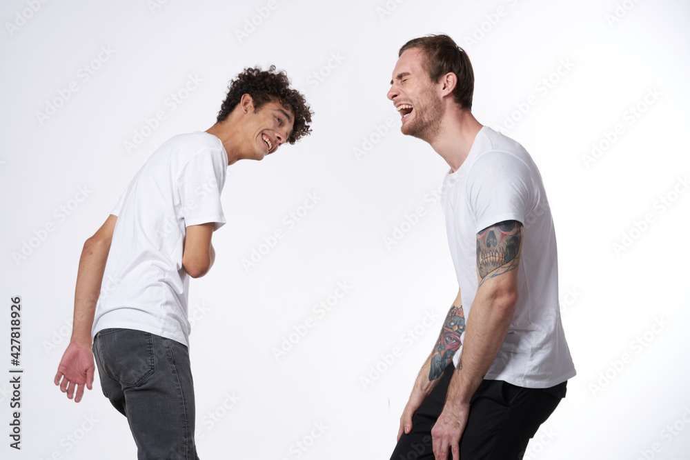 Two cheerful friends in white T-shirts joy Positive light background Two cheerful friends in white T-shirts joy Positive light background