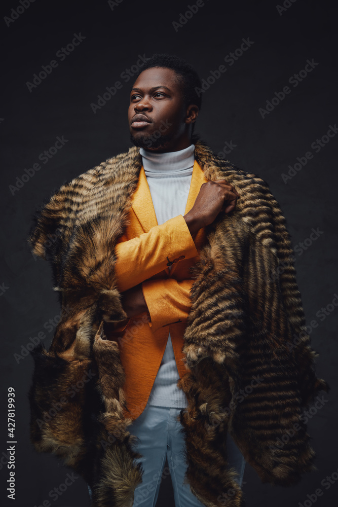 Stylish black hipster with fur posing in dark background Stylish black hipster with fur posing in dark background