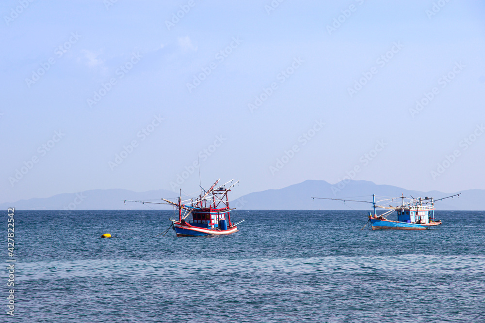Obraz premium Traditional thai fishing boat floating in the sea of thailand near koh larn on day the bright sky.