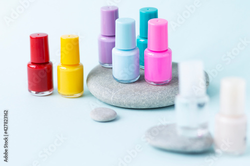 Small glass bottle of red nail polish on a stone. Mockup for manufacturers of different shades of nail polish with copy space. Professional manicure concept