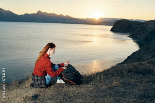 woman on vacation resting in the mountains near the sea at sunset