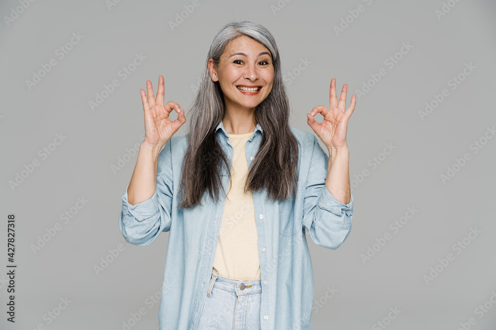 Mature white-haired woman smiling and showing ok sign Mature white-haired woman smiling and showing ok sign