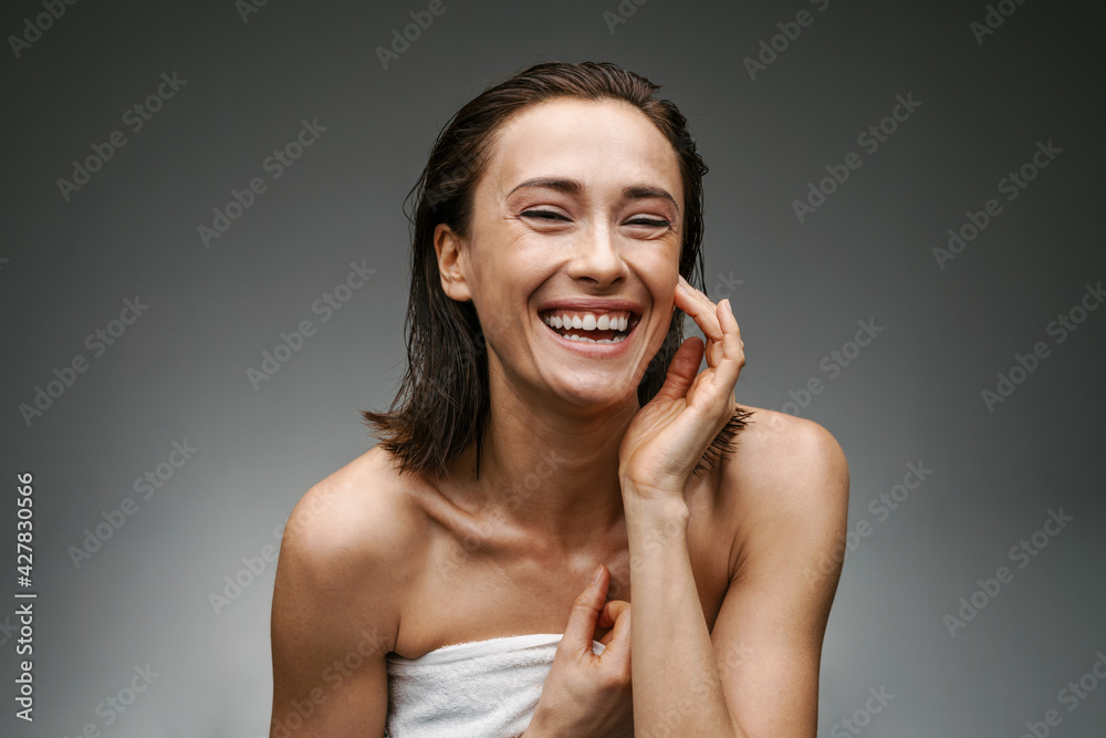 White woman dressed in towel laughing and looking at camera White woman dressed in towel laughing and looking at camera