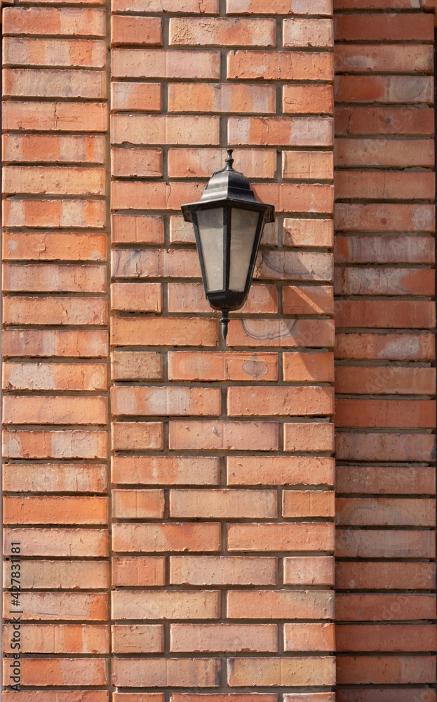 Retro style lamp and decorative masonry walls made of red brick shaped bricks