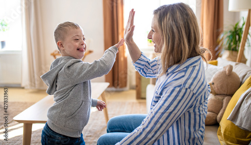 Obraz na plátně Single mother playing with down syndrome child at home.