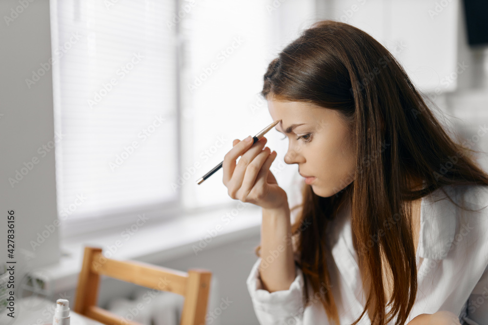 woman with pencil eyeliner foundation makeup at home woman with pencil eyeliner foundation makeup at home