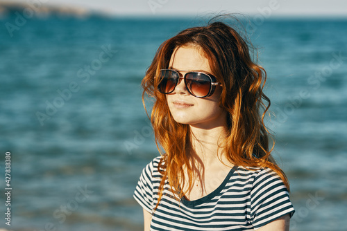 portrait of a red-haired woman in sunglasses in the mountains near the sea and smile laughing travel  © SHOTPRIME STUDIO