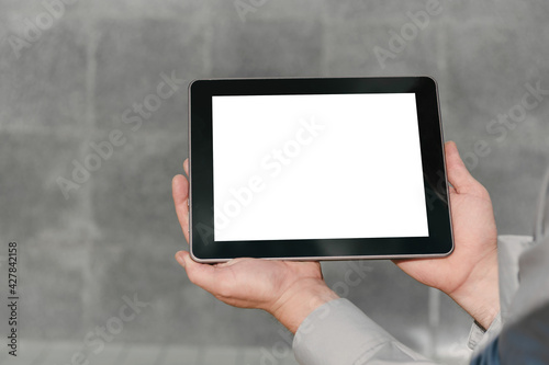 Close up, Mock up tablet, presentation of business plan, man hands. against the background of a concrete wall.
