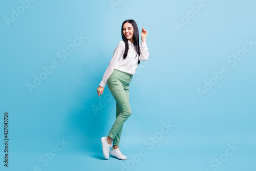 Full size profile side photo of young attractive woman happy positive smile have fun isolated over blue color background