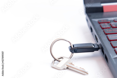 Key and USB flash driven type C into laptop computer on white background. Encryption and protection for data security concept.