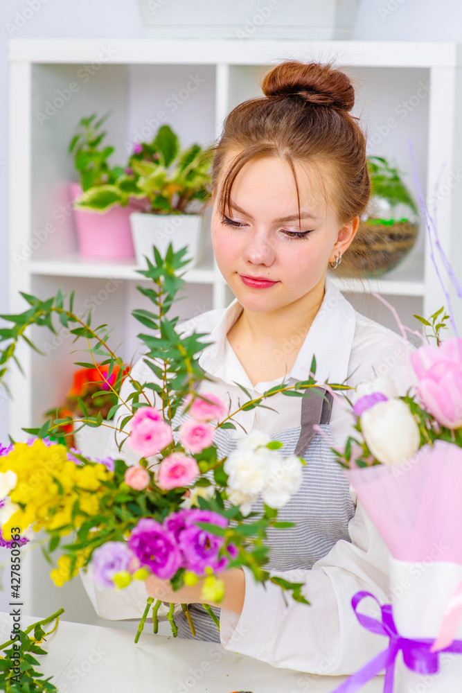 Startup successful small business. Businesswoman owner female standing behind counter with  flowers in floral shop. Girl portrait, successful owner, eco friendly concept .