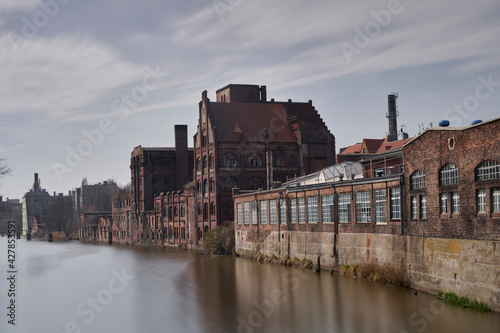Stare po przemysłowe budynki nad brzegiem rzeki w mieście Szczecin
