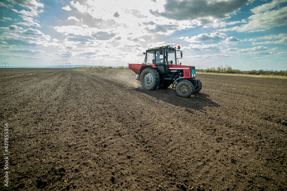 Obraz premium Tractor spreading artificial fertilizers